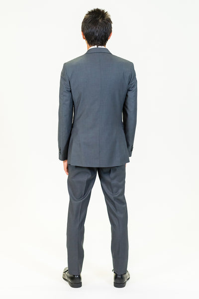 high school student boy wearing charcoal grey suit standing back view