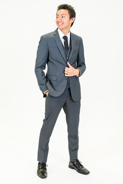 high school student boy wearing charcoal grey suit black tie standing facing left