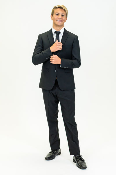 high school student boy wearing black polyester suit black tie standing adjusting left cuff