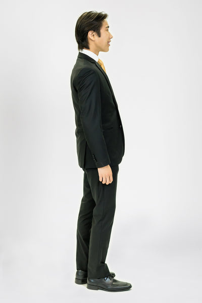 high school student boy wearing black tuxedo gold neck tie side view standing