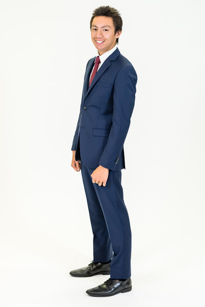 high school student boy wearing navy suit red bow tie standing side view 